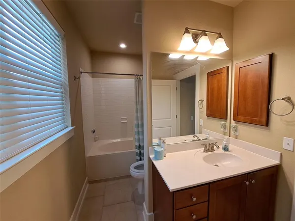 a bathroom with a sink a toilet a tub and shower