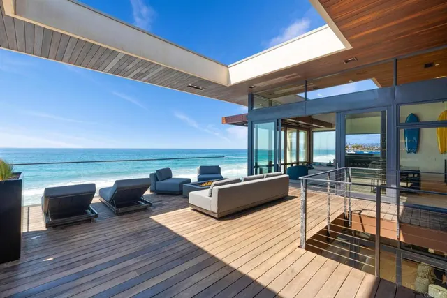 a view of a roof deck with couches and wooden floor