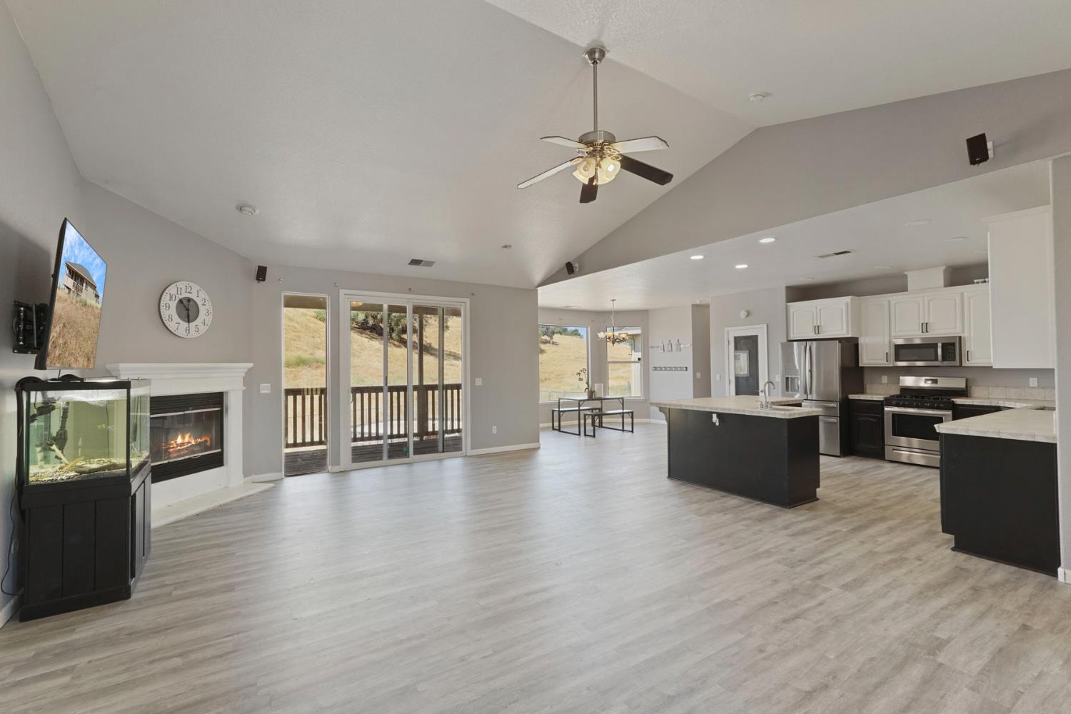 a view of a livingroom with furniture wooden floor and a kitchen