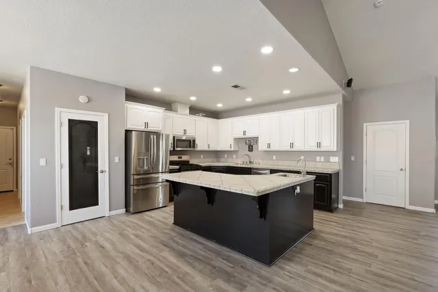 a spacious bedroom with a bed a couch and a large window