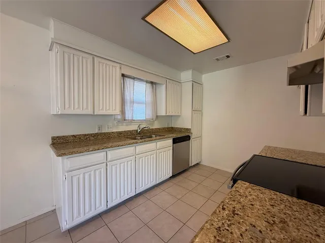 a kitchen with a sink cabinets and a window