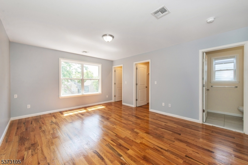 848 Lafayette Street Elizabeth, NJ 07201 - Photo 12 of 21 an empty room with wooden floor and windows