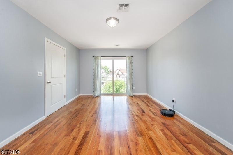 848 Lafayette Street Elizabeth, NJ 07201 - Photo 3 of 21 a view of an empty room with wooden floor and a window