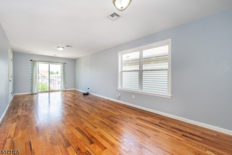 848 Lafayette Street Elizabeth, NJ 07201 - Photo 4 of 21 a view of empty room with wooden floor and fan