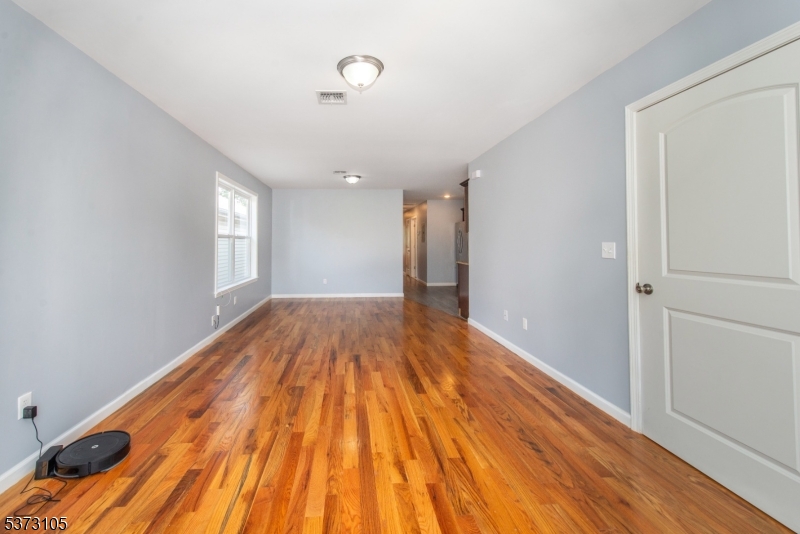 848 Lafayette Street Elizabeth, NJ 07201 - Photo 5 of 21 a view of empty room with wooden floor and fan