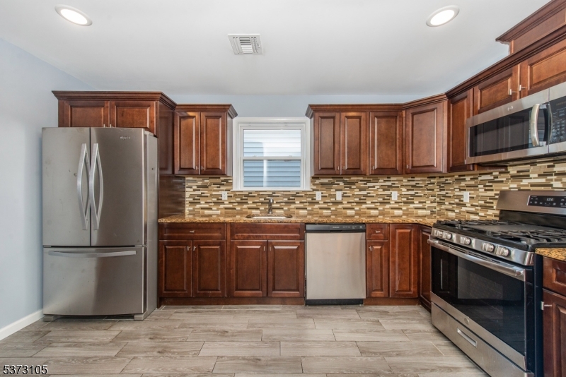 848 Lafayette Street Elizabeth, NJ 07201 - Photo 7 of 21 a kitchen with stainless steel appliances granite countertop a refrigerator stove a sink and a microwave