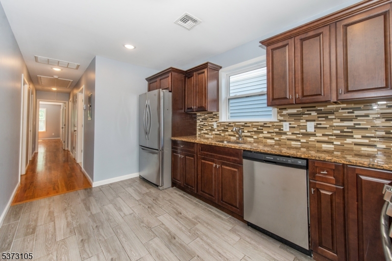 848 Lafayette Street Elizabeth, NJ 07201 - Photo 9 of 21 a kitchen with stainless steel appliances granite countertop wooden cabinets a refrigerator and dishwasher