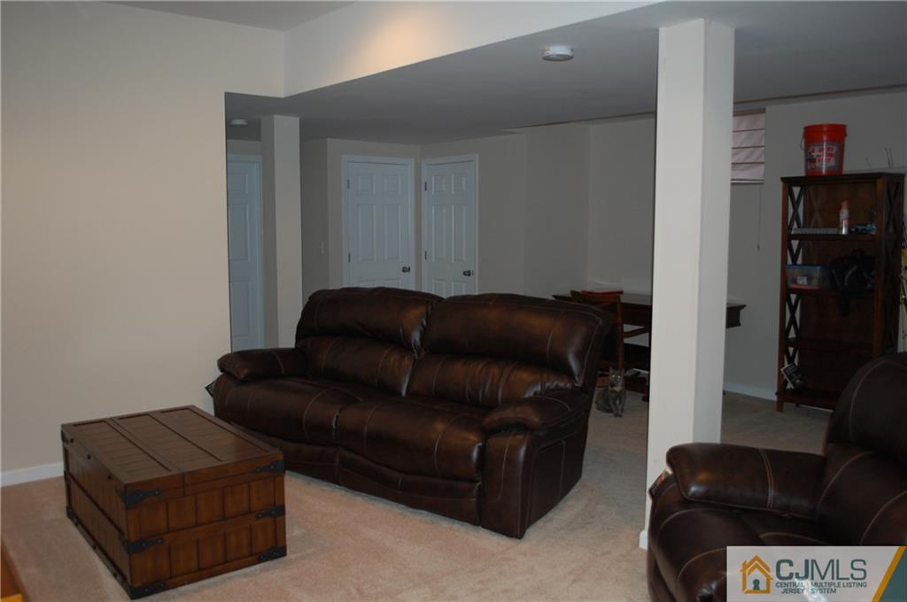 146 Cottrell Road Old Bridge, NJ 07747 - Photo 22 of 25 a living room with a couch and a book shelf