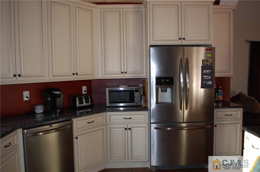 146 Cottrell Road Old Bridge, NJ 07747 - Photo 6 of 25 a kitchen with stainless steel appliances granite countertop a refrigerator a stove a microwave and white cabinets