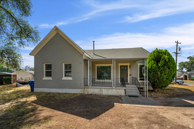 327 35th Street Ogden, UT 84401 - Photo 1 of 31 Stucco exterior with a pitched roof, featuring a covered front porch with decorative iron railings