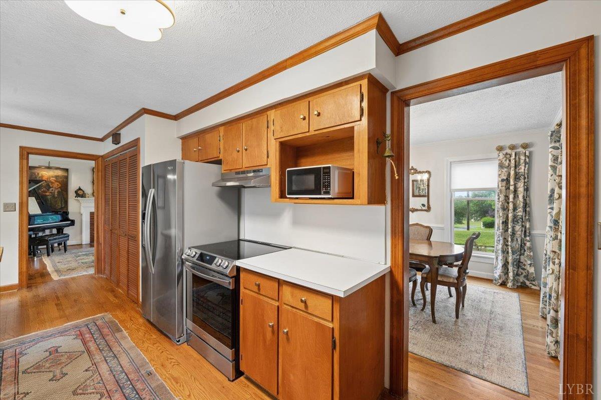 3289 Peaks Road Bedford, VA 24523 - Photo 15 of 71 a kitchen with stainless steel appliances granite countertop a refrigerator a stove and a dining table with wooden floor
