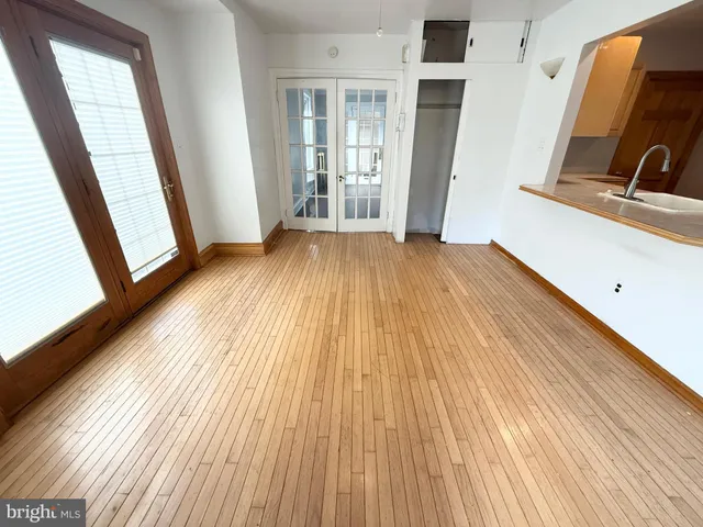 a view of a room with wooden floor and a window