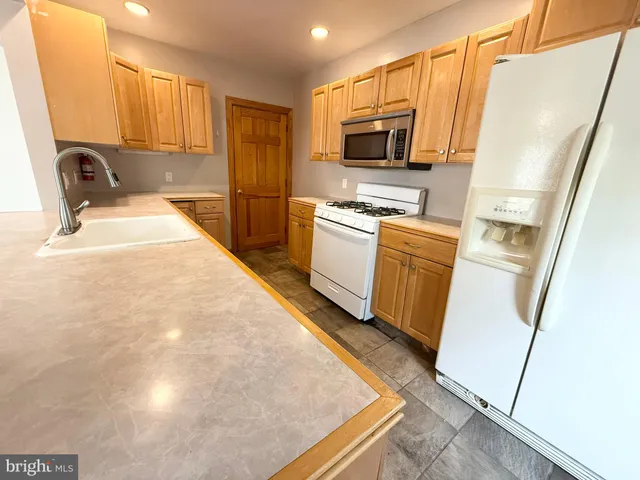 a kitchen with sink a microwave a stove and refrigerator