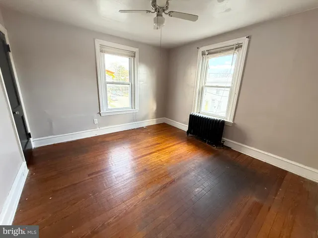 a view of room with window ceiling fan and hardwood floor