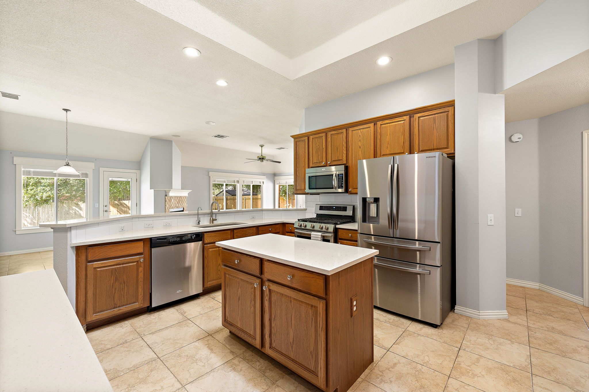 1102 Nelson Ranch Road Cedar Park, TX 78613 - Photo 17 of 37 A well-equipped kitchen features a central island, stainless steel appliances, and tile flooring for easy maintenance.