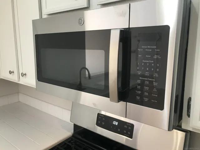 a kitchen with a refrigerator stove and wooden cabinets