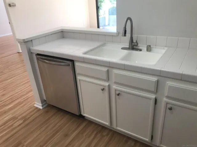 a kitchen with a sink and wooden floor