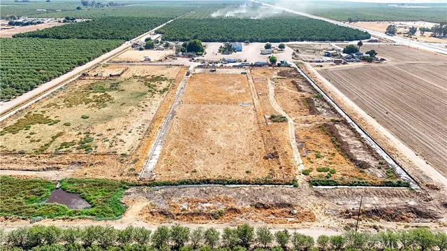 a view of swimming pool with a lawn chairs and large trees