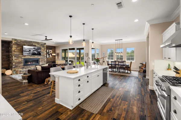 a large white kitchen with lots of counter space a sink a stove and white cabinets