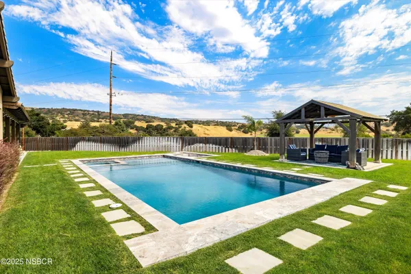 a front view of a house with swimming pool garden and patio