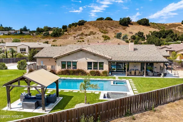 a view of a house with pool and chairs