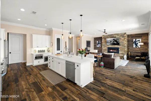 a large white kitchen with lots of counter space a sink appliances and cabinets