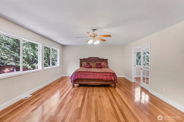 a bedroom with a bed and wooden floor