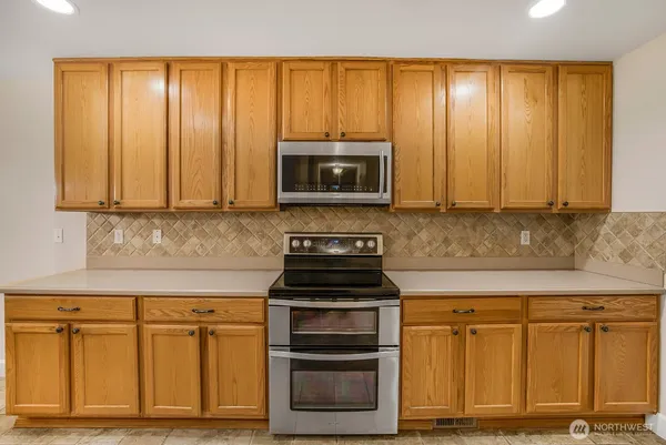 a kitchen with granite countertop wooden cabinets and a stove top oven
