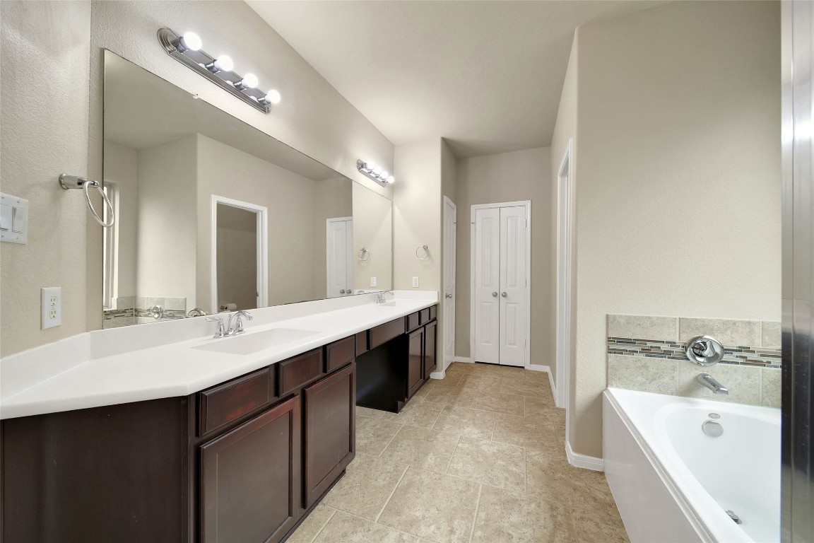 4419 Fenway Park Way Spring, TX 77389 - Photo 15 of 36 a spacious bathroom with a double vanity sink a large mirror and a bathtub