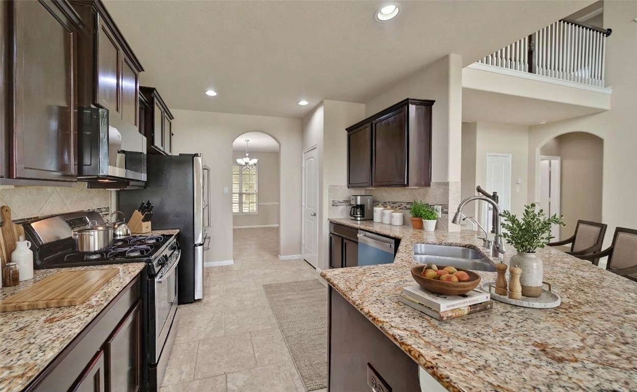 4419 Fenway Park Way Spring, TX 77389 - Photo 6 of 36 a kitchen with granite countertop kitchen island stainless steel appliances a sink stove top oven and cabinets