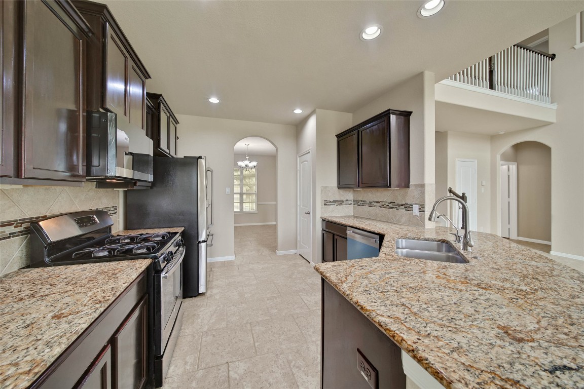 4419 Fenway Park Way Spring, TX 77389 - Photo 7 of 36 a kitchen with stainless steel appliances granite countertop a sink stove and cabinets