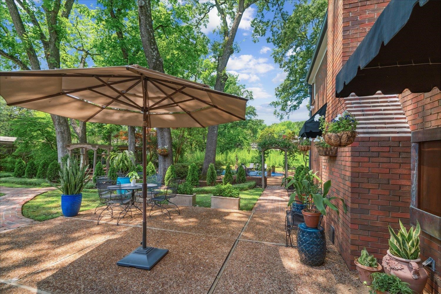 4585 Walnut Grove Road Memphis, TN 38117 - Photo 29 of 36 a view of a patio with a table and chairs under an umbrella