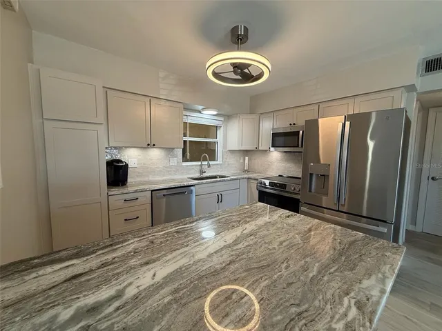 a kitchen with cabinets appliances and a window