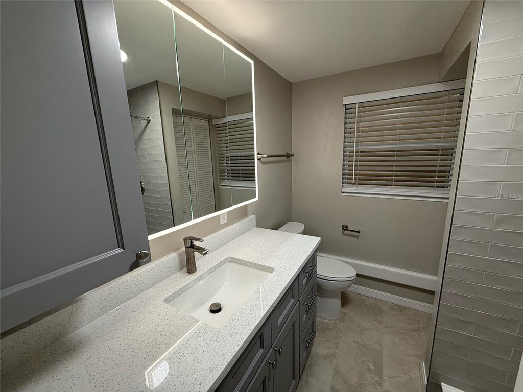 175 55th Avenue, Unit 109 St. Pete Beach, FL 33706 - Photo 18 of 27 a bathroom with a sink a toilet and shower