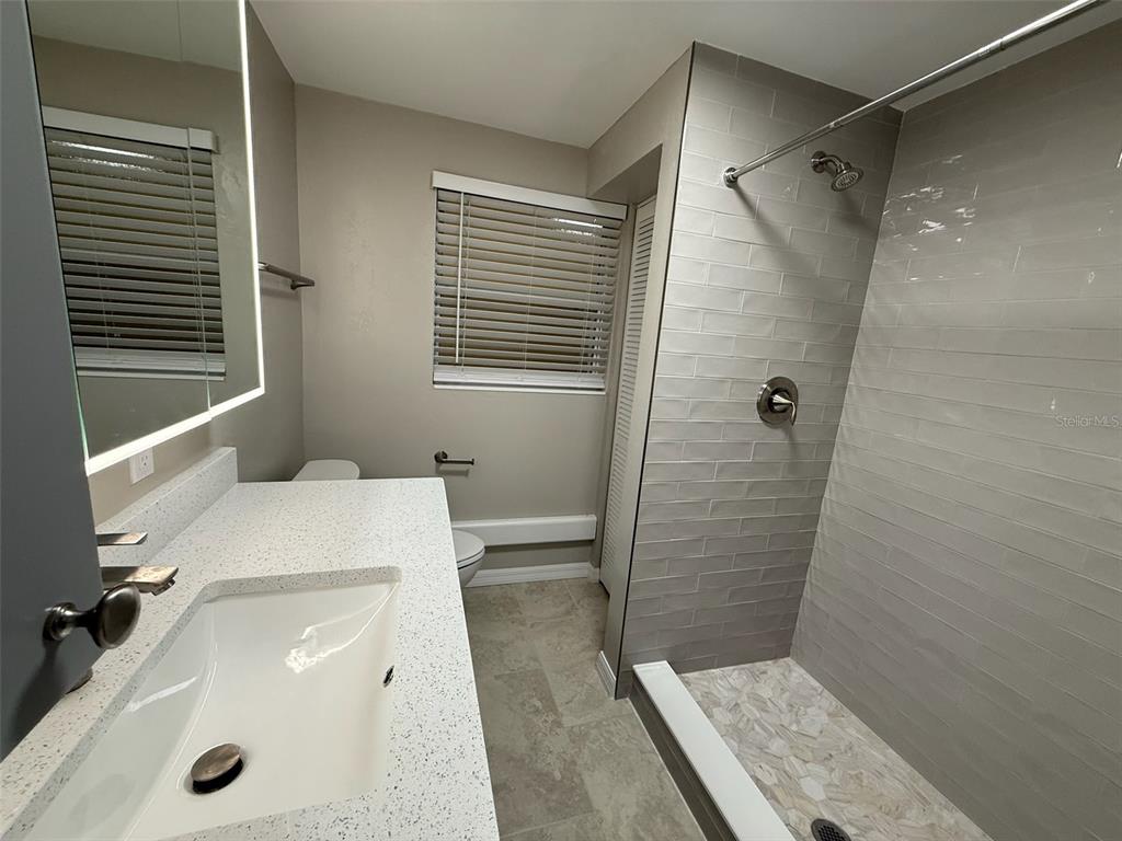 175 55th Avenue, Unit 109 St. Pete Beach, FL 33706 - Photo 19 of 27 a bathroom with a sink a toilet and shower