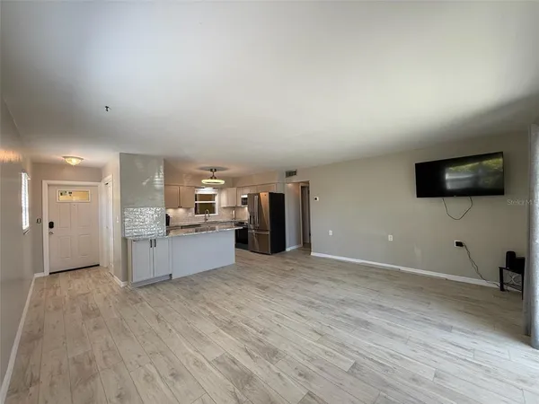 a view of a kitchen with furniture and wooden floor