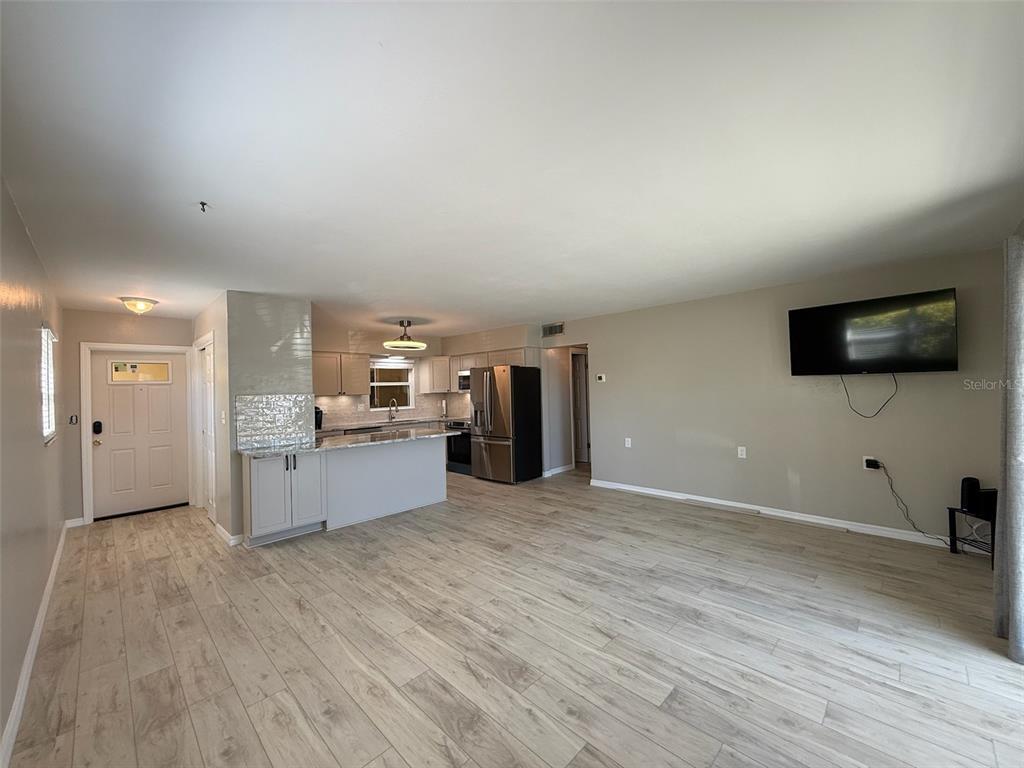 175 55th Avenue, Unit 109 St. Pete Beach, FL 33706 - Photo 4 of 27 a large kitchen with a wooden floor and a sink