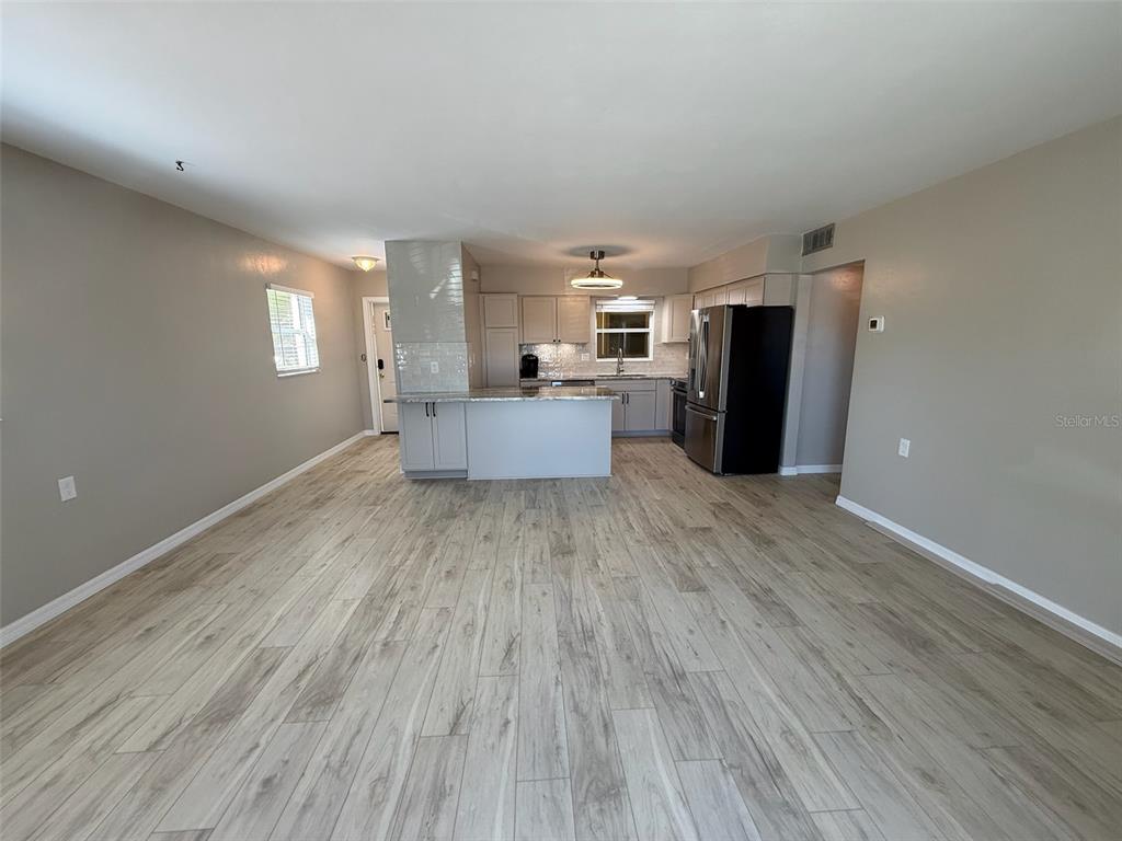 175 55th Avenue, Unit 109 St. Pete Beach, FL 33706 - Photo 5 of 27 a view of a kitchen with furniture and wooden floor