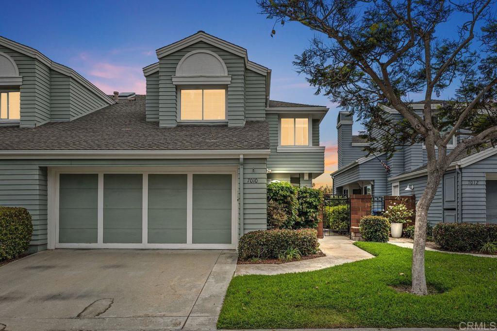 a front view of a house with a yard and potted plants
