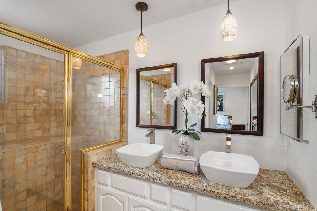 7010 Lantana Terrace Carlsbad, CA 92011 - Photo 26 of 45 a bathroom with a granite countertop sink and a mirror