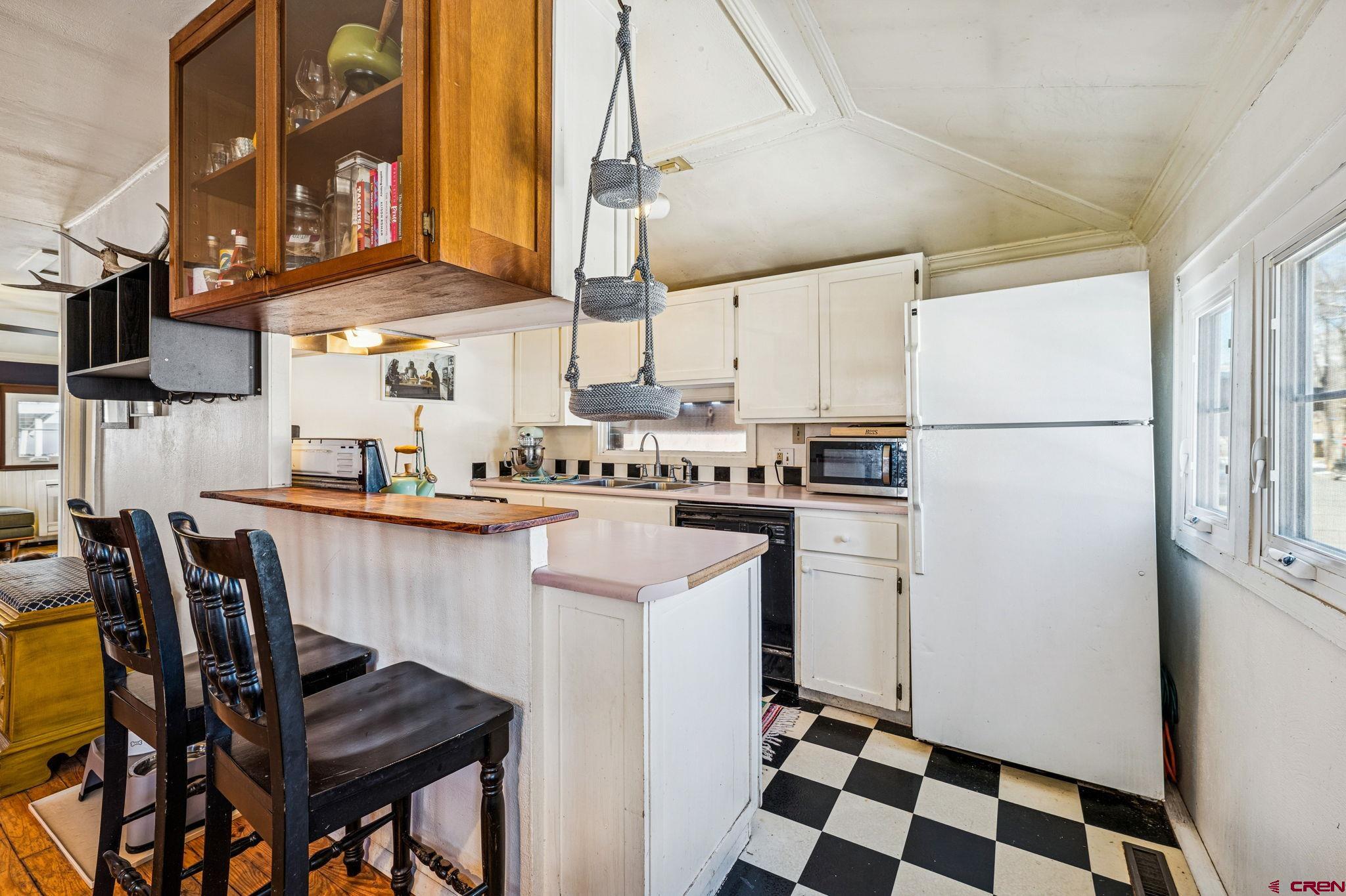 476 East 5th Street Durango, CO 81301 - Photo 39 of 40 a kitchen with stainless steel appliances a refrigerator a sink a stove and white cabinets