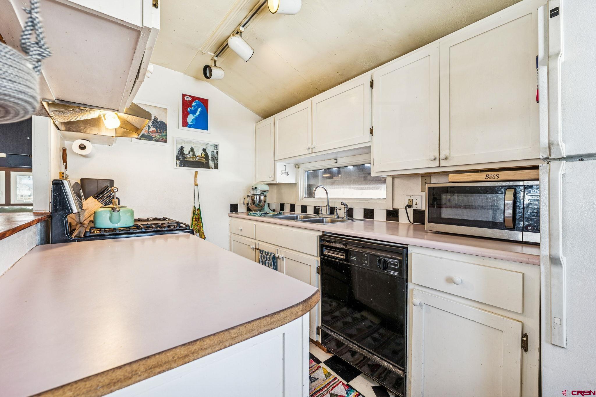 476 East 5th Street Durango, CO 81301 - Photo 40 of 40 a kitchen with granite countertop a sink stainless steel appliances and white cabinets