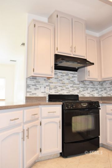 919 Sims Street Ridgecrest, CA 93555 - Photo 9 of 32 a kitchen with granite countertop white cabinets and stainless steel appliances