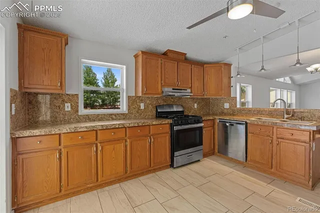 a kitchen with stainless steel appliances granite countertop a stove sink and cabinets
