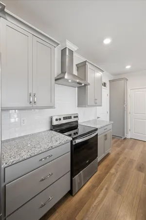 a kitchen with stainless steel appliances granite countertop a stove a sink and a wooden floors