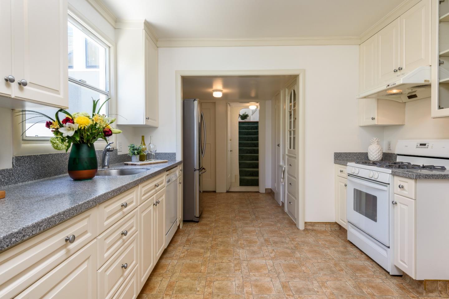 439 Primrose Road Burlingame, CA 94010 - Photo 13 of 28 a kitchen with stainless steel appliances a sink stove and cabinets