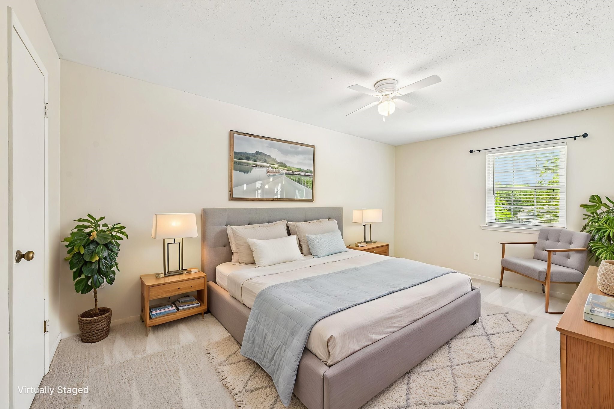 8 Arlington Street Conroe, TX 77301 - Photo 6 of 37 Bedroom #3 upstairs featuring a comfortable bed, neutral decor, and natural light from a window with blinds. It includes a ceiling fan, two nightstands with lamps, a cozy chair, and a decorative plant, creating a welcoming and serene atmosphere.