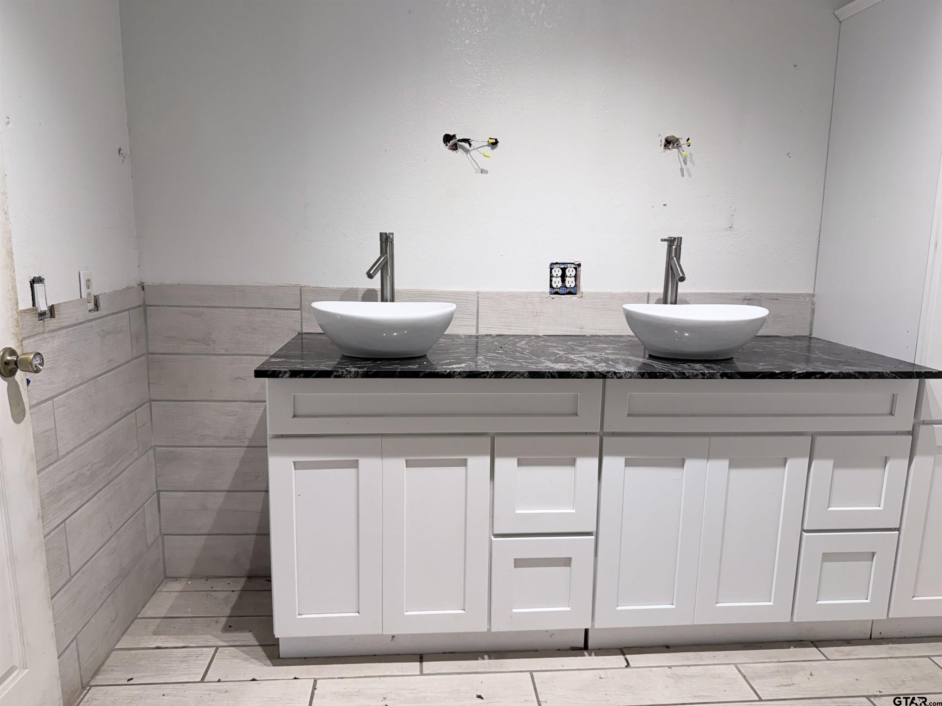 14946 County Road 220 Tyler, TX 75707 - Photo 32 of 41 a bathroom with a granite countertop sink and white cabinets