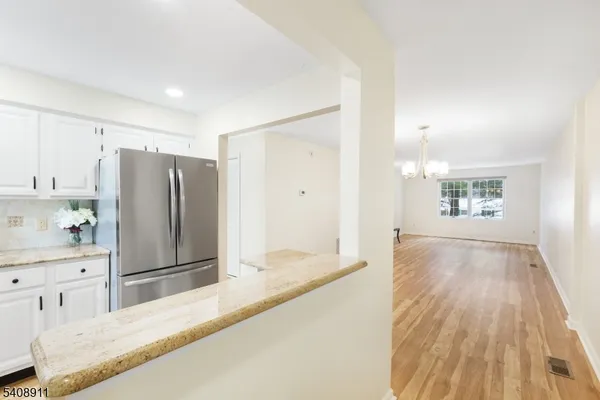 a spacious bathroom with a granite countertop sink and a refrigerator