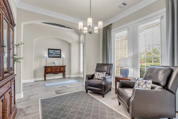 a living room with furniture and a chandelier